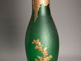 un vase vert orné d'un motif à la feuille d'or