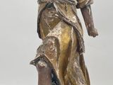 bronze statue of a woman holding a bird on a wooden base