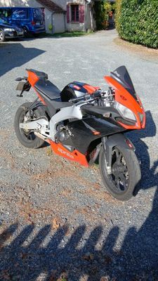 une moto garée sur le gravier devant une maison