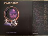 two pink floyd albums sitting on top of a table next to each other