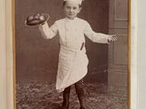 une vieille photo d'un petit garçon en tenue de chef