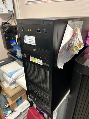un ordinateur noir posé sur un bureau dans un coin de la pièce
