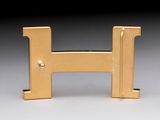 gold metal letter h on a white surface