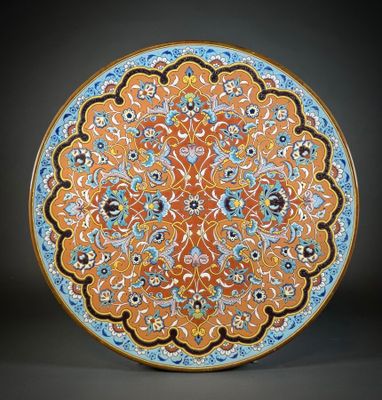 an orange and blue plate with a floral design on it