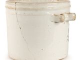 a white pot with a handle on a white surface