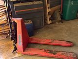 une photo d'un garage avec deux paires de skis posées par terre