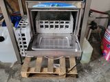 a dishwasher that is sitting on a pallet in a room