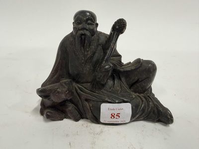 une image représentant la statue d'un homme assis sur un rocher
