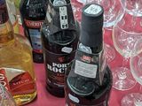 many bottles of alcohol sitting on a table with wine glasses