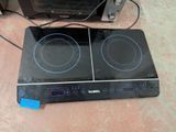 a black stove top with two burners and a toaster oven