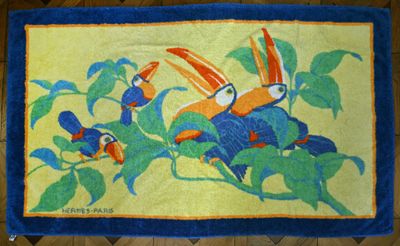 un tapis sur lequel sont représentés deux oiseaux, posé sur un parquet