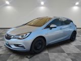 une Opel argentée garée sur un sol en damier dans un garage