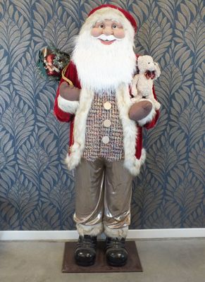 une statue représentant le Père Noël tenant un ours en peluche