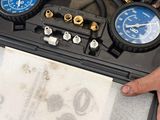 a man holding a box with a couple of gauges in it