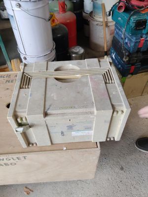 un homme debout à côté d'une pile de cartons dans un garage