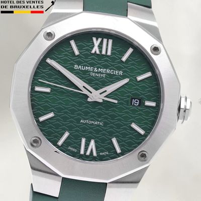 a green watch with roman numerals on the face