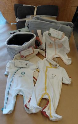 de nombreux vêtements de bébé étalés sur une table dans une pièce
