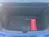 the trunk of a blue car with a red box in the trunk