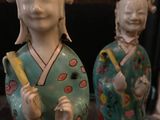 two figurines of asian women standing next to each other
