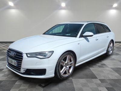 L'Audi blanche est garée sur un sol en carrelage à damier.
