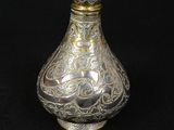 a silver and gold vase on a black background