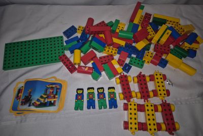 a pile of legos on a bed next to a picture frame