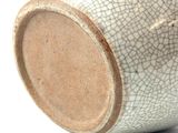 a close up of a white and brown vase on a white surface