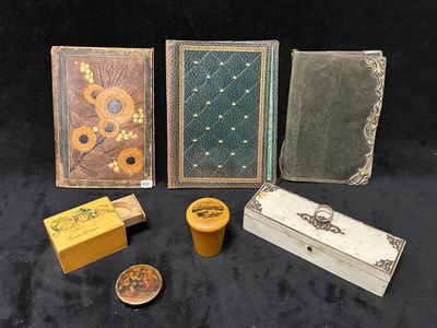 quatre livres, une boîte, une bougie et un bougeoir posés sur une table