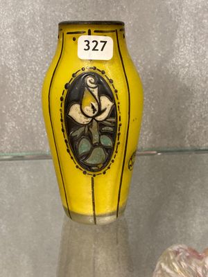 a yellow vase with a picture of a woman on it