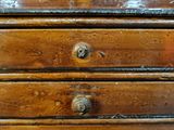 a small wooden chest of drawers with many drawers on it