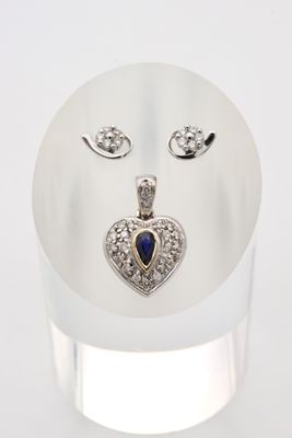 un gros plan sur une bague ornée d'un cœur et une paire de boucles d'oreilles