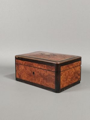 une vieille boîte en bois avec un couvercle, posée sur une surface grise