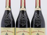 trois bouteilles de vin rouge posées l'une à côté de l'autre sur une surface blanche