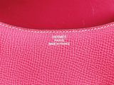 a close up of a pink purse with two metal letters