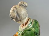 a figurine of a man holding a banana in his hand