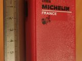 un livre rouge posé à côté d'une règle sur une table