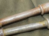 two metal pipes that are sitting on a green cloth