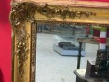 a mirror on the table in front of a red wall