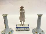 trois vases posés sur une table, avec une figurine représentant une femme