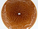 an image of a brown plate with flowers and leaves on it