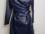 La robe est en cuir et a des manches longues.
