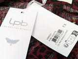 the label on the shirt is attached to a red and black leopard print shirt