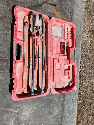 une mallette à outils rouge posée par terre, contenant des outils