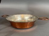 a metal pan and a metal bowl on a table