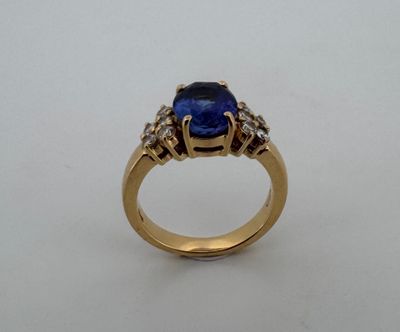 Gros plan sur une bague en or ornée d'un saphir bleu et de diamants