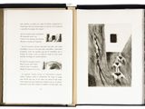 an open book with a black and white drawing of a person climbing a mountain