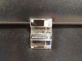 the back of a black leather briefcase with a metal clasp