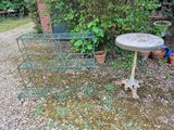 une petite table sur laquelle se trouve un bain d'oiseaux, dans le jardin