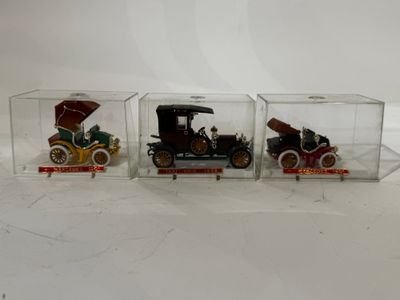 trois petites voitures miniatures dans une vitrine en verre