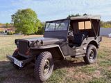 une vieille jeep garée dans l'herbe par une journée ensoleillée